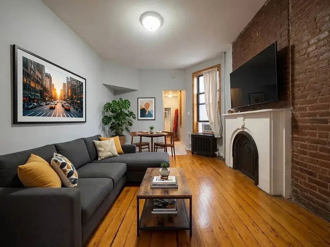One bedroom at 13 Saint Marks Place, living room with exposed brick and a fireplace