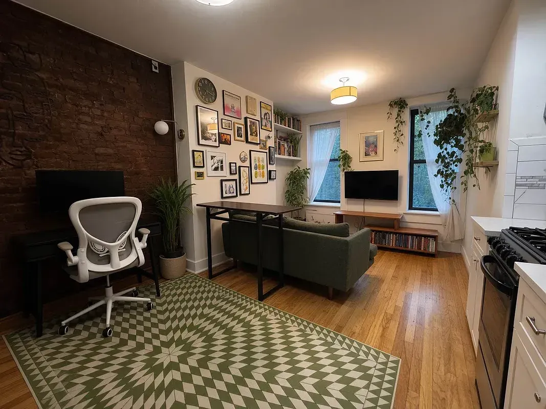 One bedroom at 518 East 6th Street, living room with exposed brick and desk