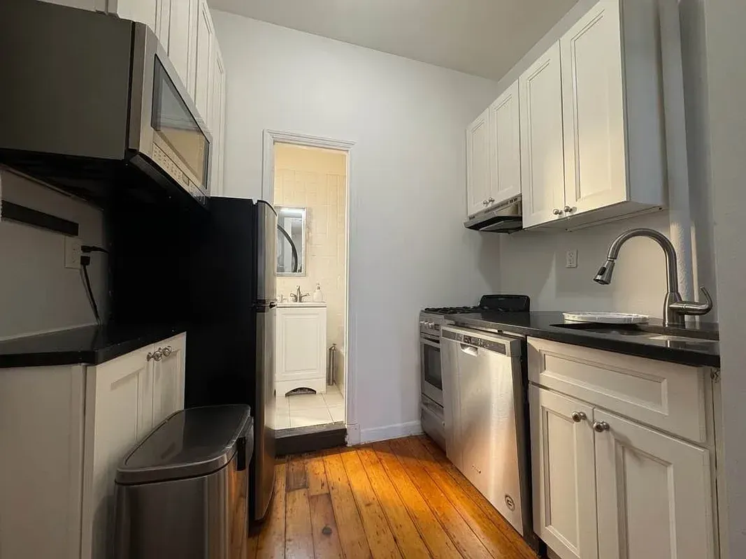 One bedroom at 13 Saint Marks Place, kitchen with white cabinets and dishwasher