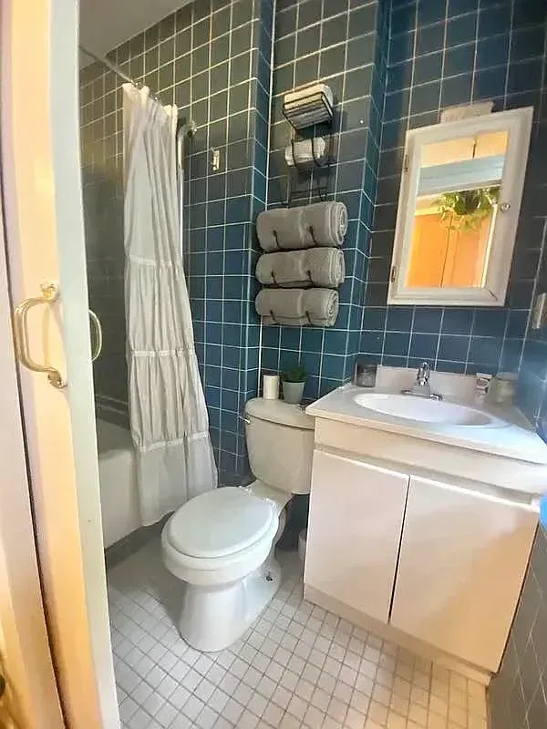 One bedroom at 520 East 6th Street, bathroom with blue tile and tub