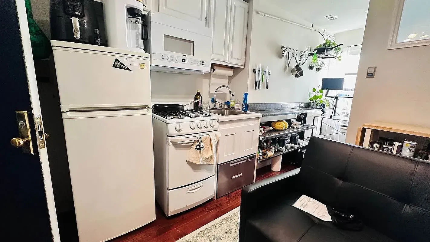 One bedroom at 518 East 6th Street, kitchen with gas range and window