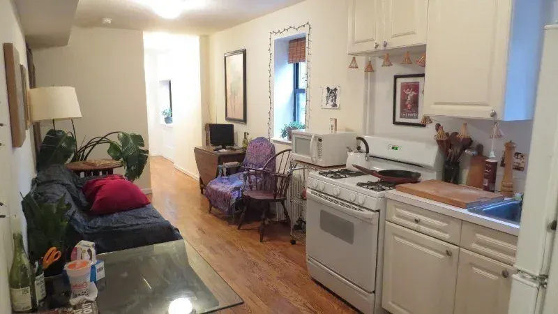 Two bedroom at 33 Saint Marks Place, living room and kitchen with white cabinets