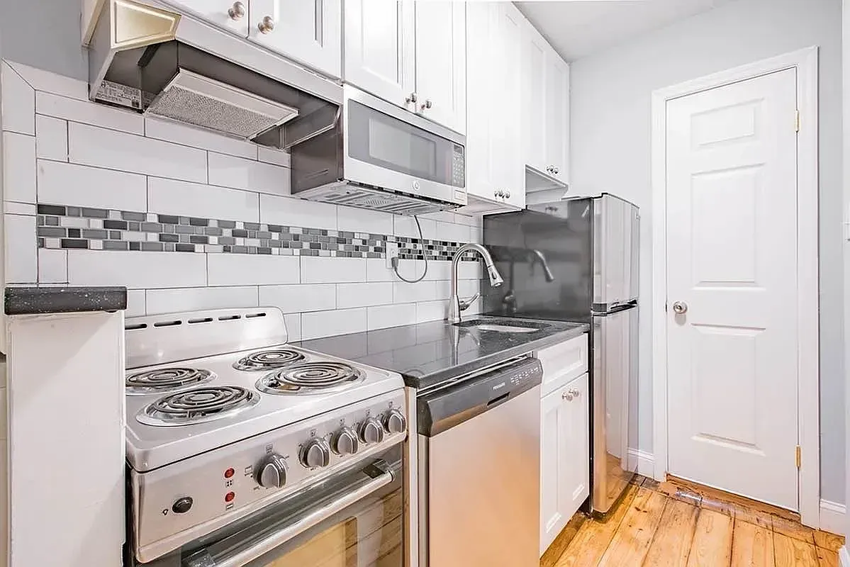 Three bedroom at 520 East 6th Street, kitchen with white cabinets and dishwasher