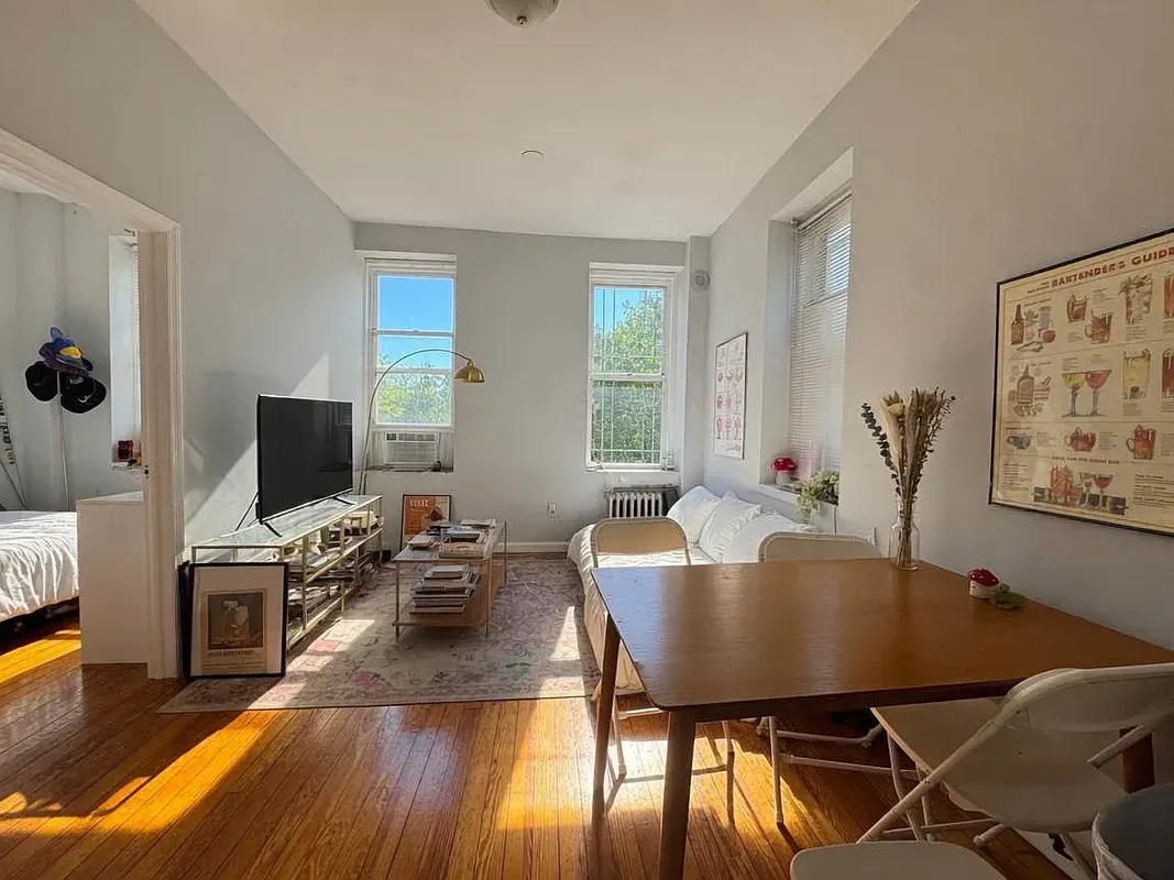 Three bedroom at 34½ Saint Marks Place, living room with dining table and two windows