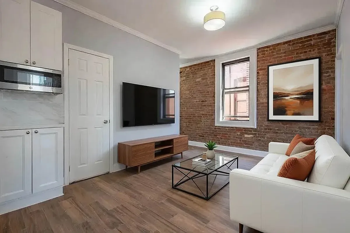 Three bedroom at 34½ Saint Marks Place, living room with exposed brick and sofa