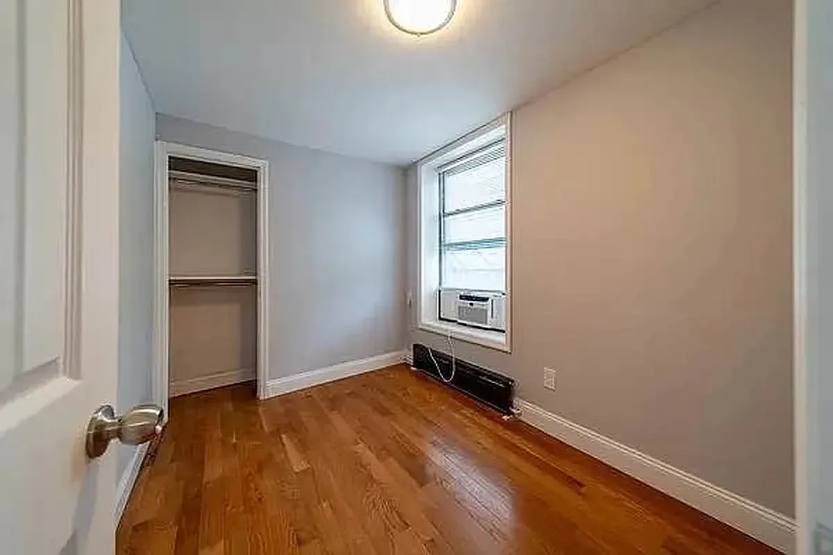 Three bedroom at 93 Avenue B, empty bedroom with built-in closet and window