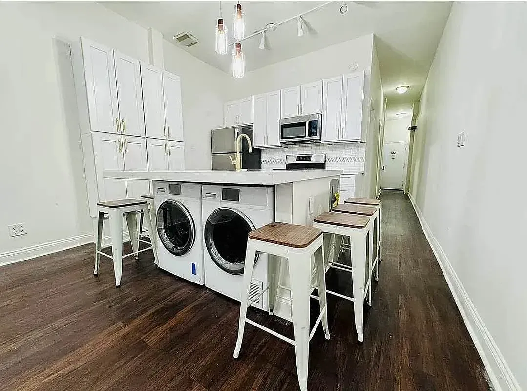 Four bedroom at 13 Saint Marks Place, kitchen island with stools, washer and dryer