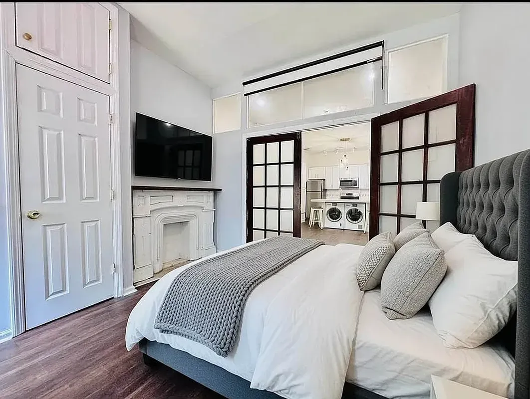 Four bedroom at 13 Saint Marks Place, bedroom with French doors and a fireplace