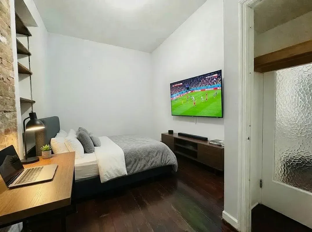 Four bedroom at 13 Saint Marks Place, bedroom with desk and wall-mounted TV
