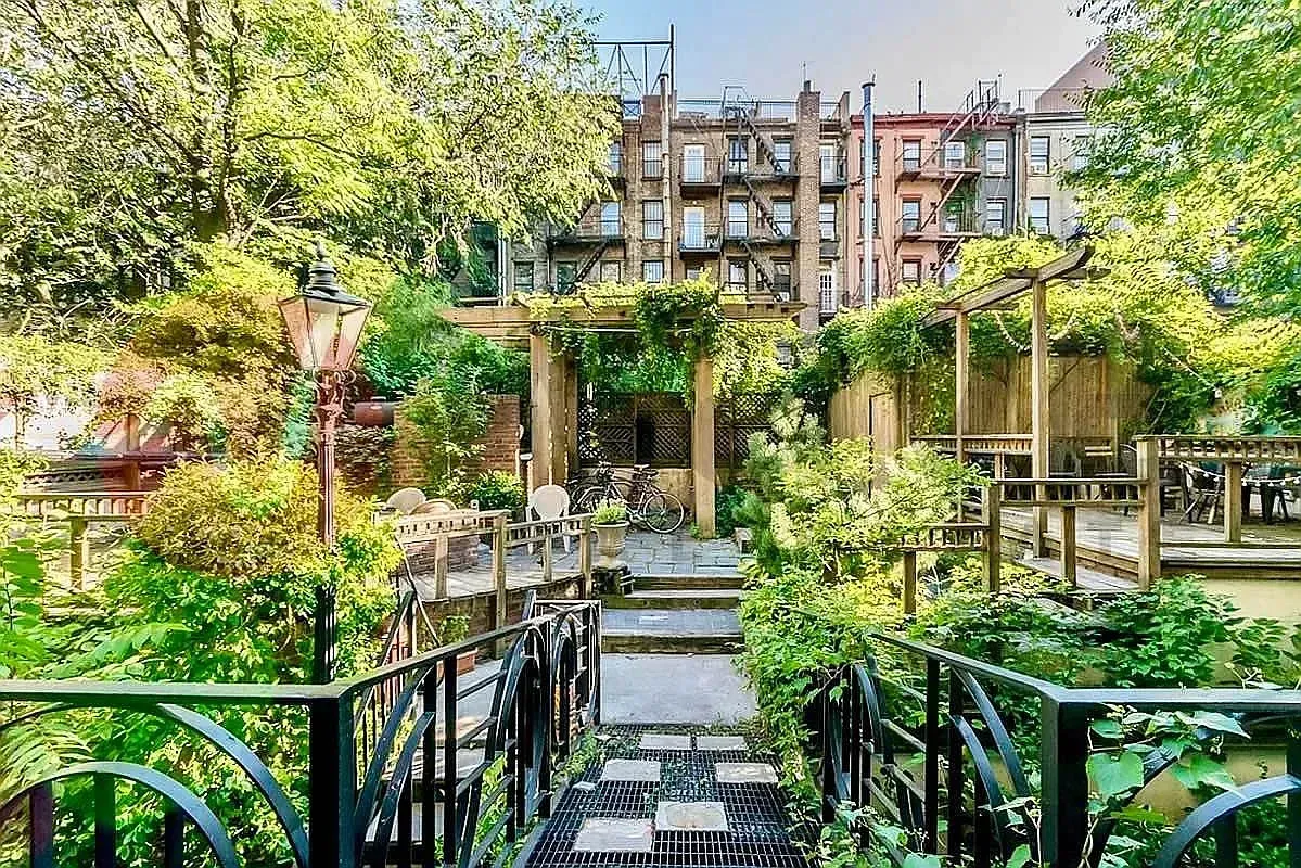 Shared garden at 518 East 6th Street, pergola and lamp post behind the building